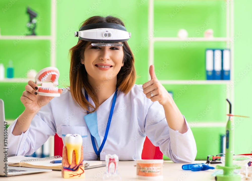 Woman dentist working on teeth implant Woman dentist working on teeth implant