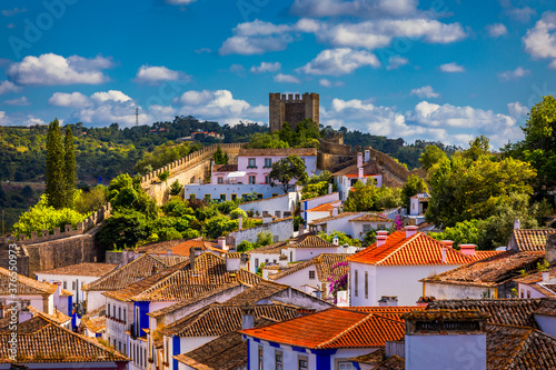 Historic walled town of Obidos, near Lisbon, Portugal. Beautiful streets of Obidos Medieval Town, Portugal. Street view of medieval fortress in Obidos. Portugal. photo