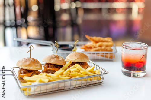 Mini burgers with french fries and cocktail served at the bar, finger food