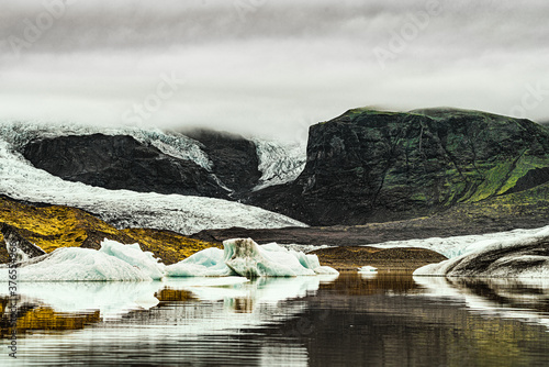 Fjallsárlón is a glacier lake at the south end of the Icelandic glacier Vatnajökull. Fjallsjökull which is part of the bigger glacier reaches down to the water of the lake and some ice-bergs are drift