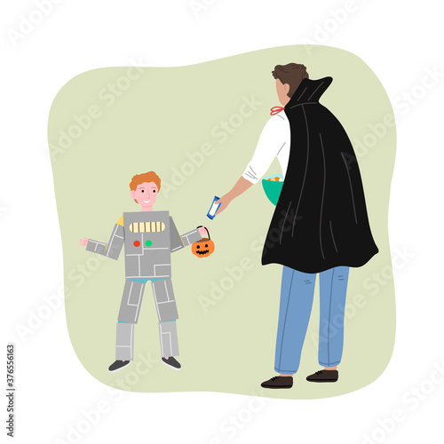 Man in costume giving sweets to smiling boy in robot costume for Halloween
