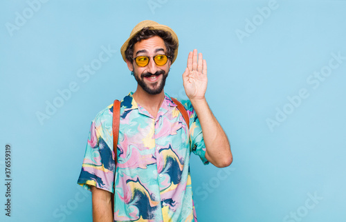 young bearded tourist man smiling, looking curiously to the side, trying to listen to gossip or overhearing a secret photo