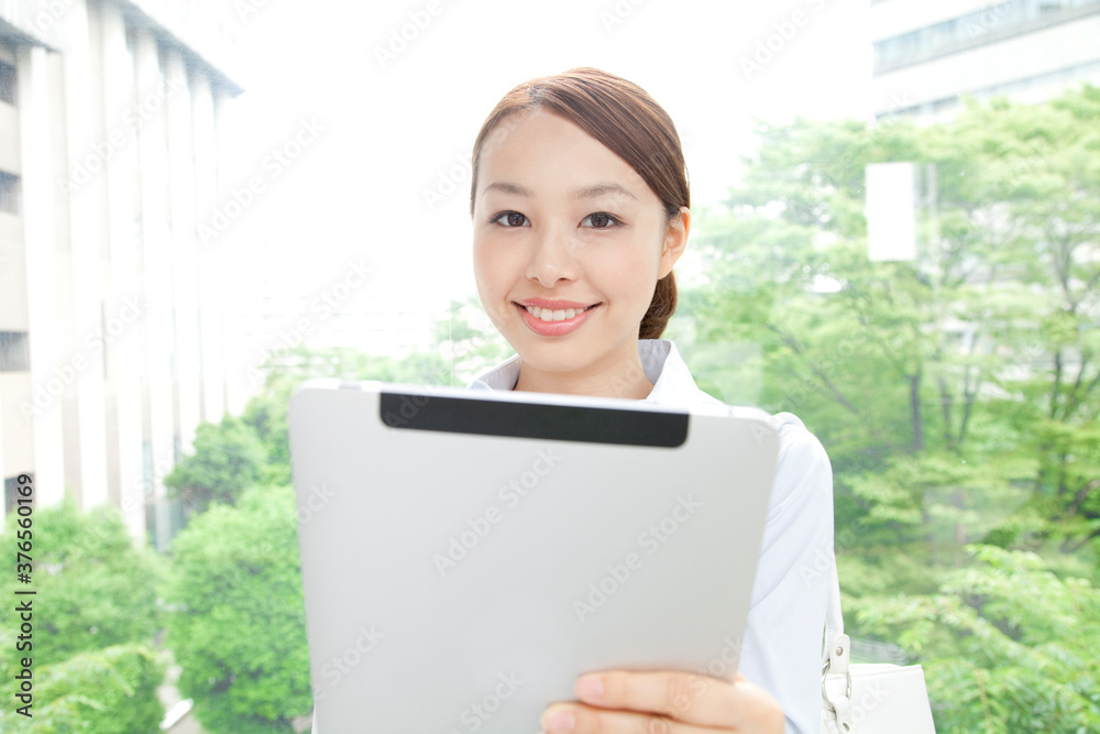 タブレットPCを持って微笑むOL タブレットPCを持って微笑むOL