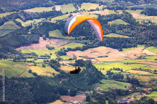 Paragliding in paradise landscape with volcano crater and lagoon in Azores. Paraglider above Lagoa das Furnas, Sao Miguel, Azores, Portugal, Europe photo