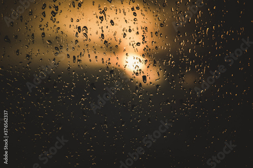The setting sun behind a rainy window.