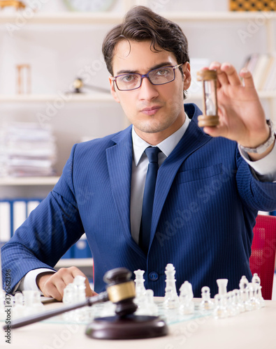 Young lawyer playing chess to train his court strategy and tacti photo