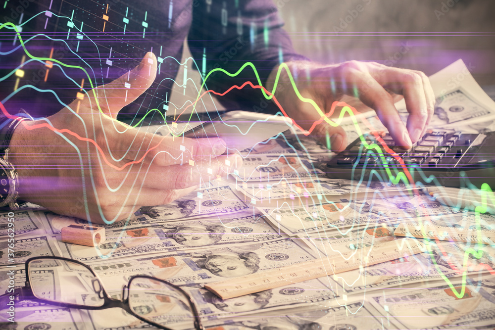 Double exposure of man's hands holding and using a digital device and forex graph drawing. Financial market concept. Double exposure of man's hands holding and using a digital device and forex graph drawing. Financial market concept.