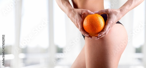 Young woman with the beautiful slim waist with orange