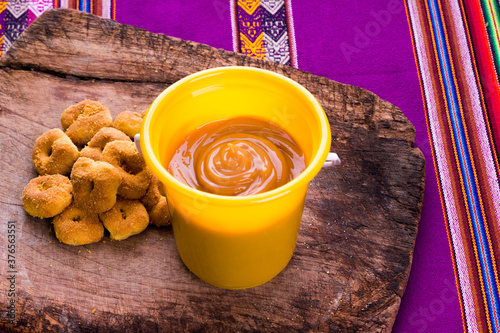 Dulce manjar blanco con rosquillas artesanales y orgánicas de los andes del Perú en mesa de madera rústica photo