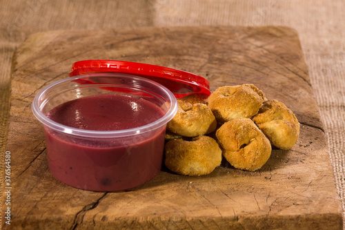 Delicioso manjar frutado con sabor a sauco acompañadas con rosquillas, rosquitas, panecillos, artesanales orgánicas desde los antes del Perú, en mesa de madera con yute photo