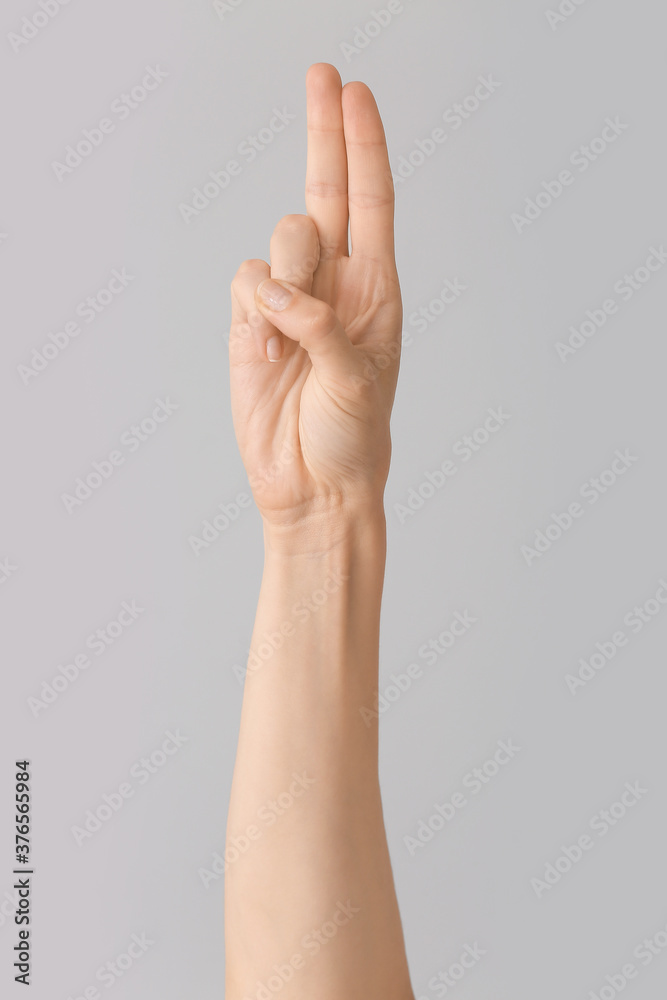 Hand showing letter U on grey background. Sign language alphabet Hand showing letter U on grey background. Sign language alphabet