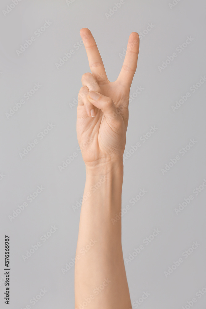 Hand showing letter V on grey background. Sign language alphabet Hand showing letter V on grey background. Sign language alphabet
