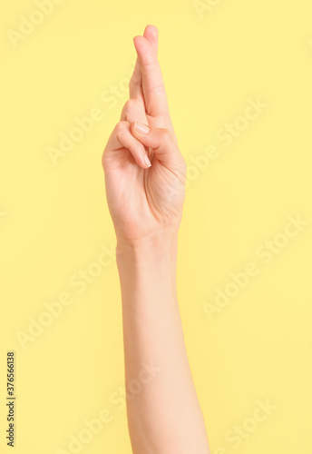 Hand showing letter R on color background. Sign language alphabet