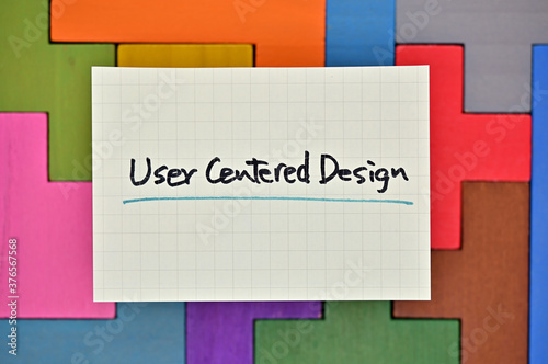 A card reading "User Centered Design" sits atop a colorful block of wood.