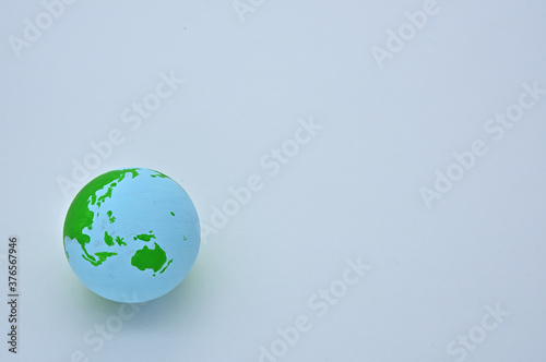 The ball of the earth is on a wooden board  and the Pacific Ocean is visible.