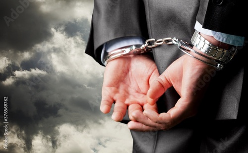 Male hands in handcuffs behind his back