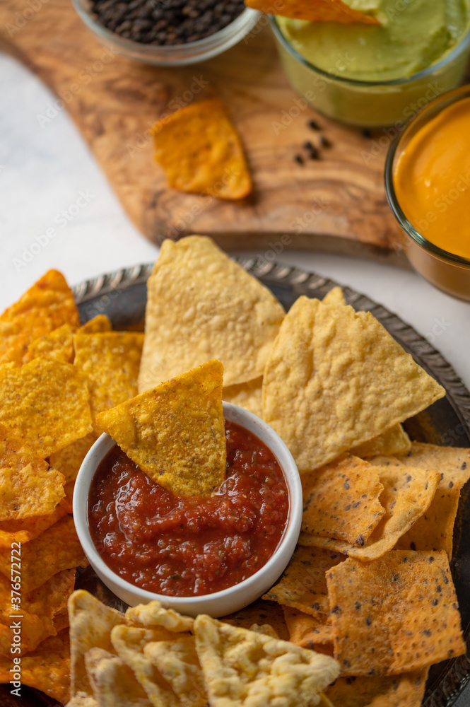Snacks and chips close-up with salsa, mexican food, on a light background Snacks and chips close-up with salsa, mexican food, on a light background