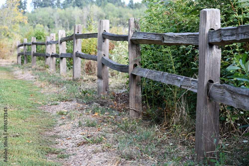 Vintage wooden fencing along rural walking path.