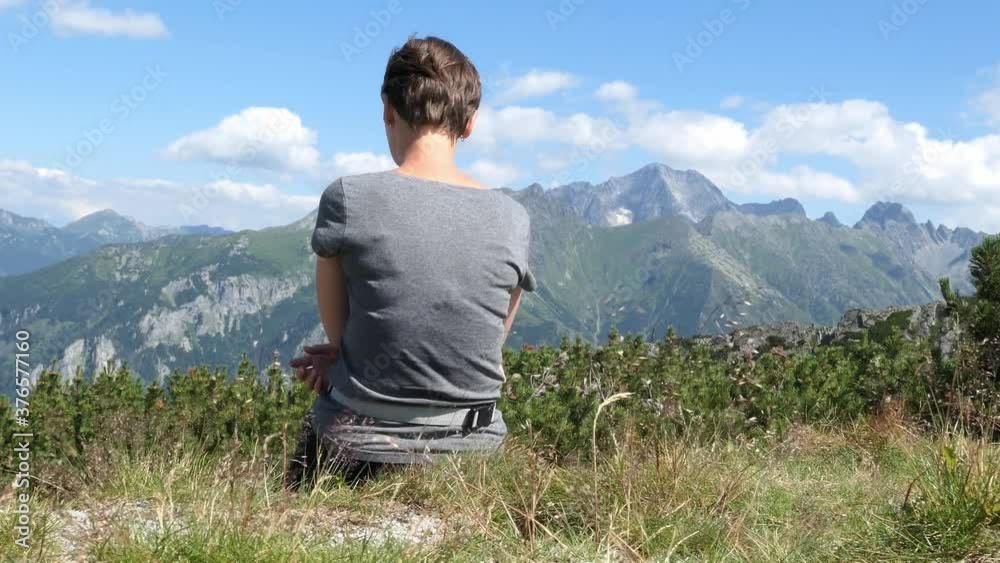 Woman Having a Rest on High Mountains Trail Enjoying Breathtaking Views Woman Having a Rest on High Mountains Trail Enjoying Breathtaking Views