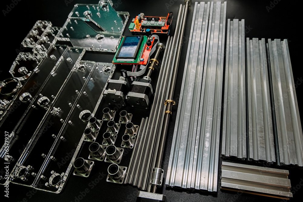 a set of parts for a laser machine on a black background, silver backlight, flat lay arduino board for controlling the machine and v slot aluminum profile lies . a set of parts for a laser machine on a black background, silver backlight, flat lay arduino board for controlling the machine and v slot aluminum profile lies .
