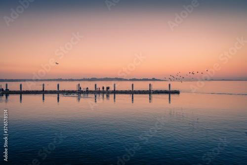 Fishing docks at sunset and birds flying around. Dreamy image.