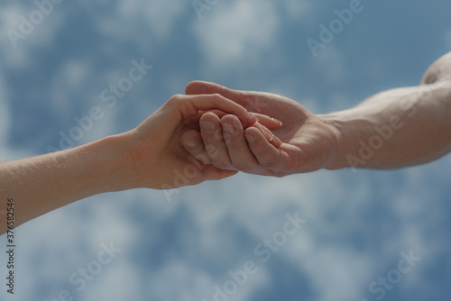 Hands on sky background. Humanity and mutual aid. Friendship.