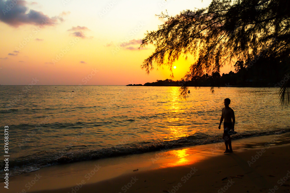 Traveler walk alone with sunset on beach