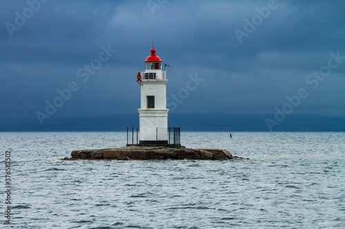lighthouse on Cape Tokarevskaya cat in Vladivostok on the background of the sea in cloudy weather © vasilevich