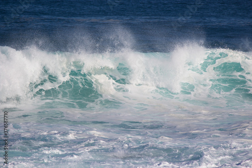 Huge  frothy waves of the Indian Ocean rolling in at famous Yallingup Beach South Western Australia a world famous surfing mecca  on a cold yet sunny late winter morning.