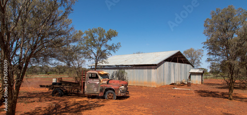 Australian Outback scene with abandoned truck and shed in the background.