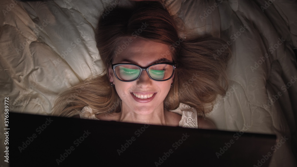 Top View Young Woman in Bed Working on a Laptop Computer at Night. Student Getting Ready to Exams, Exceptionally Dedicated Project Manager Finishing Work in Bed at Night.