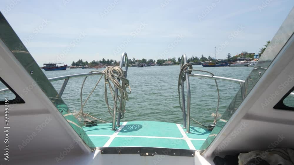 A view in front of a fast motorboat traveling in the ocean on summer day.