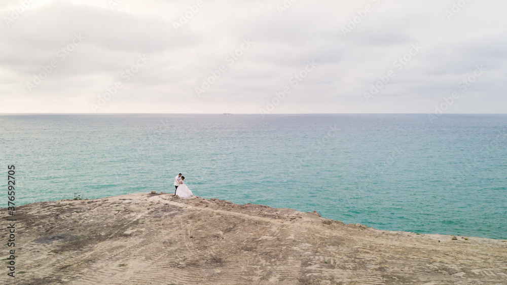 Bride and Groom with white tuxedo holding each other outdoor posing Bride and Groom with white tuxedo holding each other outdoor posing
