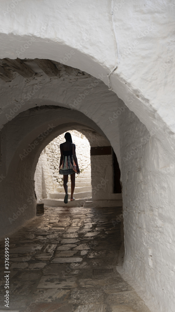  Dark-skinned young attractive woman in backlight at the exit in the arch