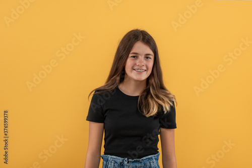 Slika na platnu Studio shot of an attractive teenager girl with braces wearing  black shirt