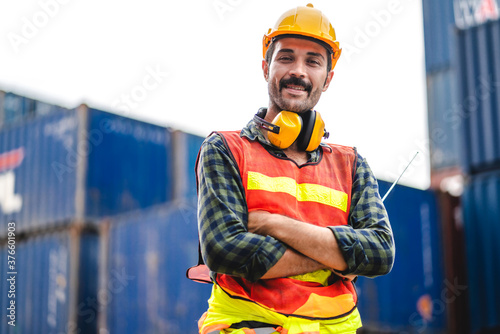 Professional engineer container cargo foreman in helmets working standing and using walkie talkie checking stock into container for loading.logistic and business export photo