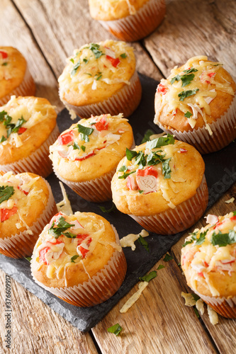 Delicious snack muffins with crab meat and cheese close-up on a slate board on the table. vertical