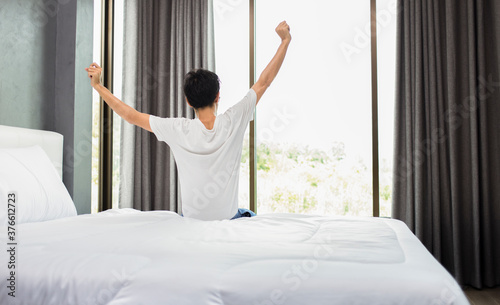 Man wake up and stretching on bed in the morning, Sweet dreams, good morning, relaxing and happy concept
