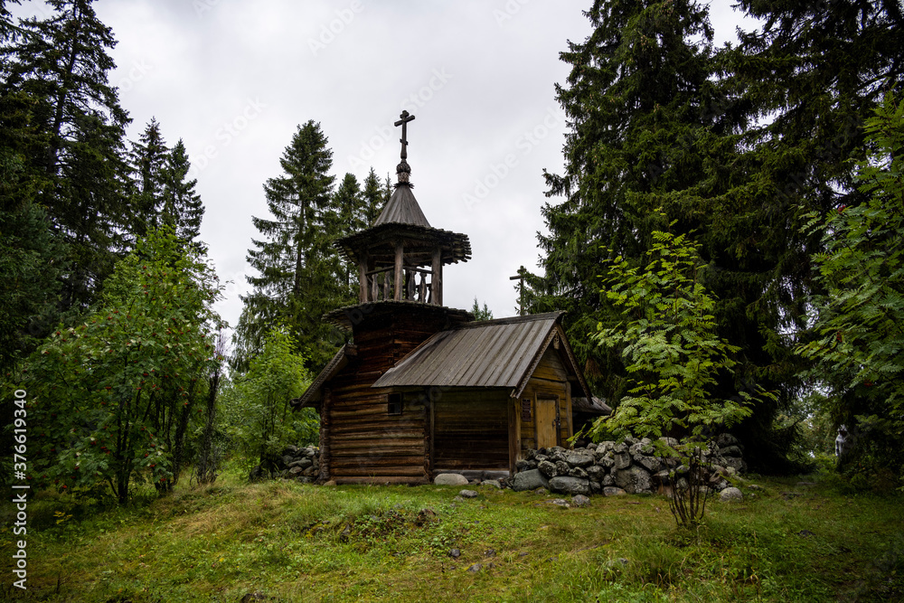 wooden ancient church on the island among the trees during the rain wooden ancient church on the island among the trees during the rain
