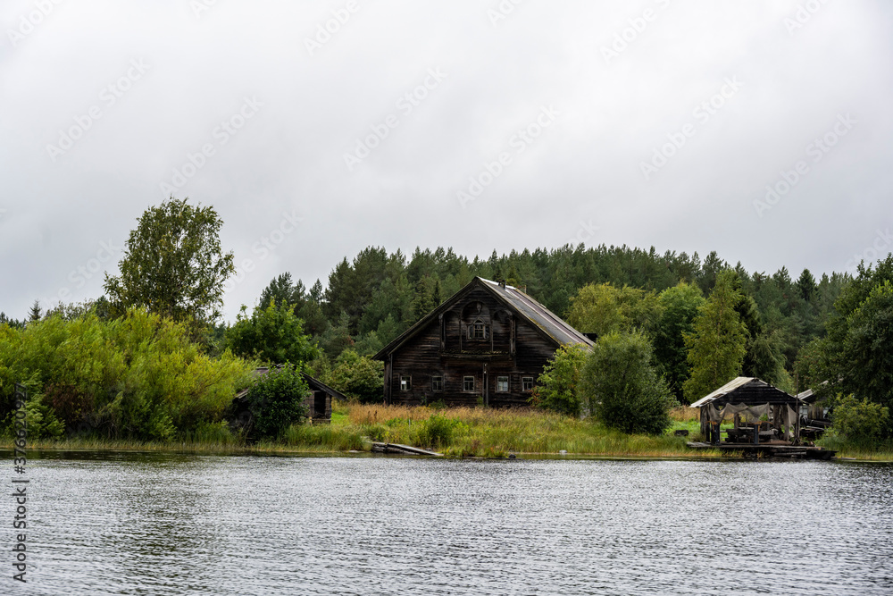 landscape with rustic wooden houses of a very old construction against the background of a gray northern sky