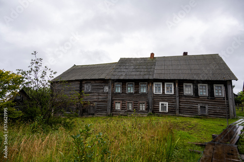 landscape with rustic wooden houses of a very old construction against the background of a gray northern sky