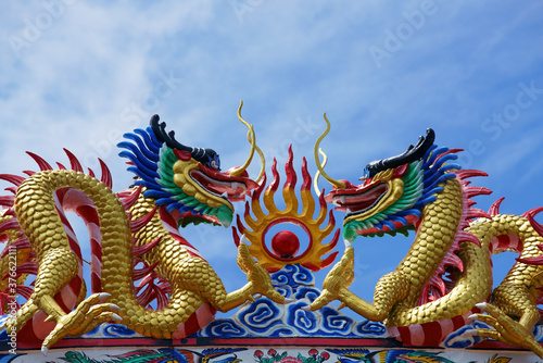dragon statue on roof against blue sky