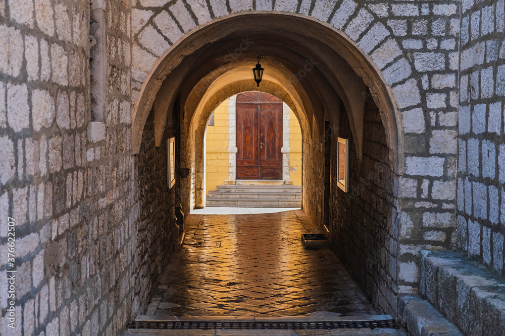 Fototapeta premium Stone gate under the cathedral tower in the old town of Krk on the island of Krk in Croatia 