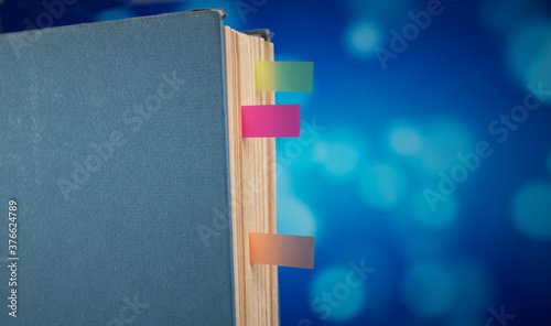 book spine with bookmarks with blue bokeh background