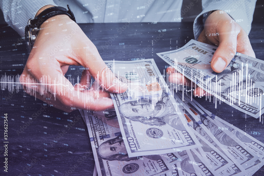 Multi exposure of financial graph drawing hologram and USA dollars bills and man hands. Analysis concept.