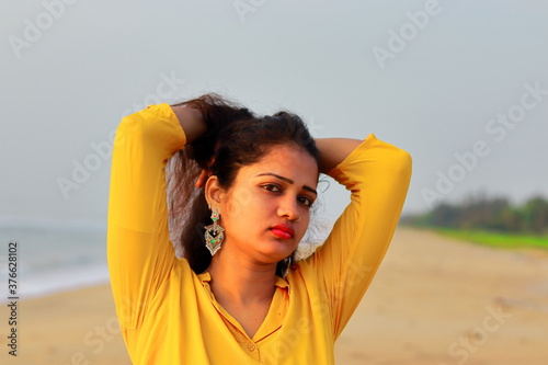 Photography A beautiful asian girl standing on the beach holding her hairs