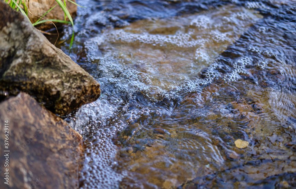 close up of water flowing into water. bubbles in water close up of water flowing into water. bubbles in water
