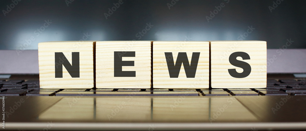 Wooden cubes with letters on a laptop keyboard.