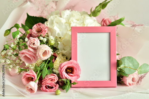 bouquet of delicate roses, eustoma, hydrangea and photoframe on light background.Flowers composition.Mother's Day, Valentine's Day,birthday. Copy space. I love you concept.Wedding invitation. © Natasha 