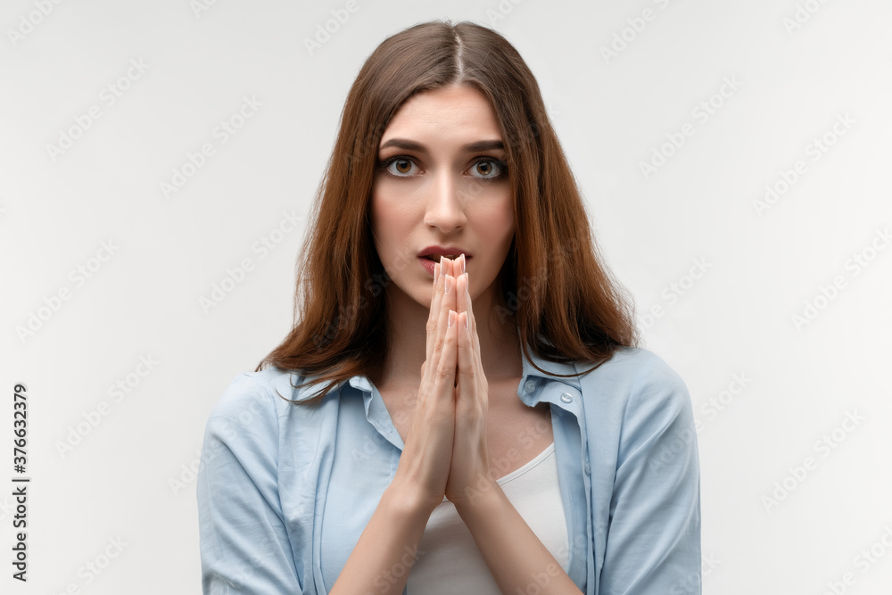 Young female holds hands in namaste sign. Meditates, praying for peace and love. Relaxation concept Young female holds hands in namaste sign. Meditates, praying for peace and love. Relaxation concept